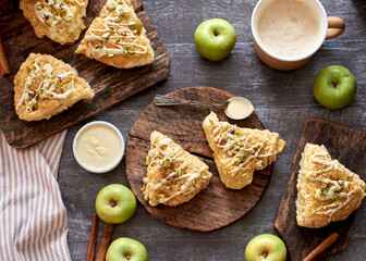 scones with apple, pistachios and white chocolate on a wooden background.