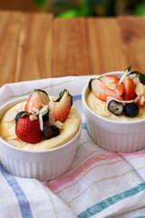 Souffle. Berries, cottage cheese, wooden background. Side view.