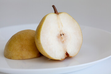 pear cut in half on a white plate