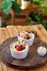 Souffle. Berries, cottage cheese, wooden background. Side view.