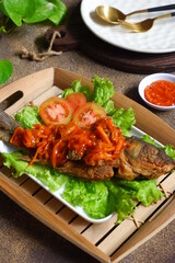 fried crispy fish with sweet and sour sauce in a plate