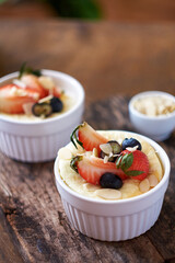 Souffle. Berries, cottage cheese, wooden background. Side view.