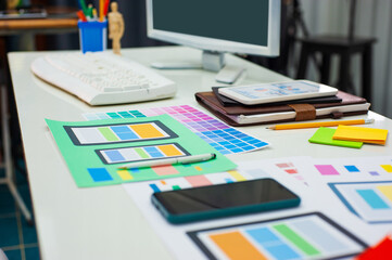 Website designer office desk and a mobile app with equipment and paperwork.