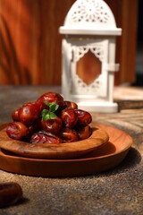 dates fruit in a wooden plate against brown background