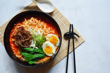 a bowl of spicy noodle with various topping or known as  ramen 