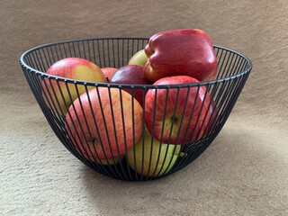 Ripe apples in a fruit bowl. Red, ripe apple in a metal vase.