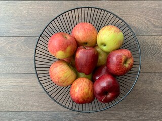 Ripe apples in a fruit bowl. Red, ripe apple in a metal vase.