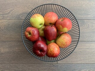 Ripe apples in a fruit bowl. Red, ripe apple in a metal vase.