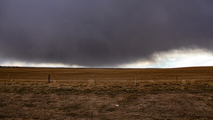 Fototapeta na wymiar Dark clouds over a farmers field, a spring storm in the prairies