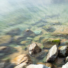 Shore rocks landscape on quiet blurry sea waters seascape