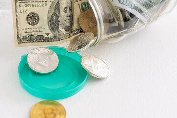 Saving money coin in jar. Symbol of investing, keeping money concept. Collecting cash banknotes in glass tin as moneybox. American dollars close-up with increasing columns of gold coins on table