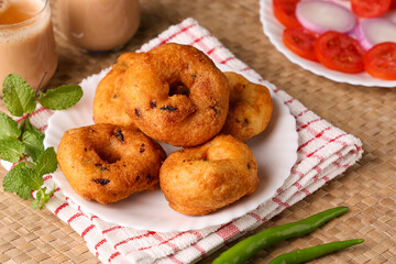 Medu Vada with tiffin sambar coconut chutney in traditional background , savory fried tea time snack of Kerala, Tamil Nadu South India. Top view of Indian veg breakfast food.