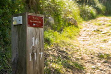 Sign on a wooden post that indicates the Camí de Cavalls path on the island of Menorca.