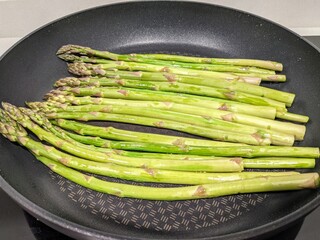 Organic and health food green asparagus in a frying pan. 