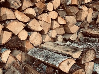 A pile of stacked firewood. Chopped wooden trunks, logs. Close-up background. Firewood.