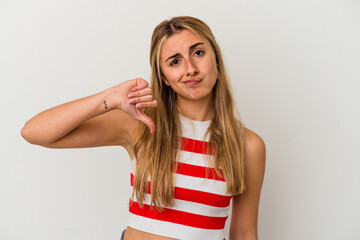 Young blonde caucasian woman on white background isolated showing a dislike gesture, thumbs down....