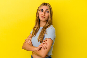 Young blonde caucasian woman isolated on yellow background dreaming of achieving goals and purposes