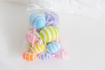 multi-colored chicken eggs in bag mesh on white background. easter
