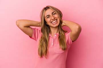 Young blonde caucasian woman isolated on pink background stretching arms, relaxed position.
