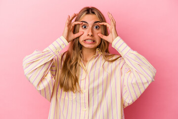 Young blonde caucasian woman isolated on pink background keeping eyes opened to find a success opportunity.