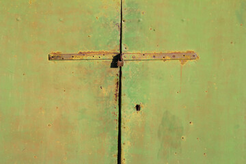 Old and rusty metal green, door, locked with  iron hasp