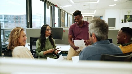 Diverse group of co-workers chatting about upcoming collaboration project holding documents 