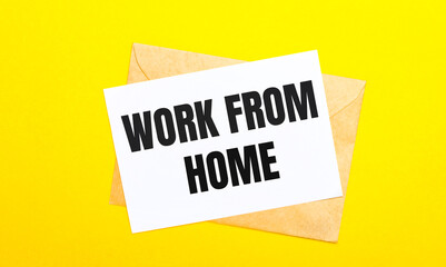 On a yellow background, an envelope and a card with the text WORK FROM HOME. View from above