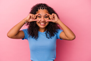 Young african american woman isolated on pink background keeping eyes opened to find a success opportunity.