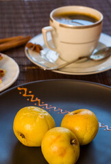 Still life - a hot cup of black coffee, homemade cookies with fruit, baked apples on a bamboo mat