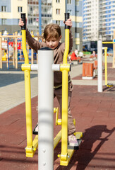Adorable little kid girl making exercises on sports training apparatus at the gym