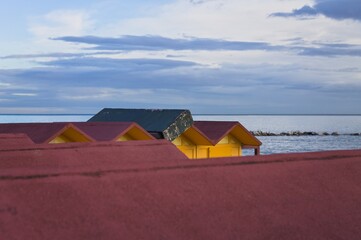 Fototapeta na wymiar Colorful beach cabins in front of the Adriatic Sea at sunrise (Pesaro, Italy, Europe)