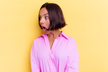 Fototapeta premium Young mixed race woman isolated on yellow background being shocked because of something she has seen.
