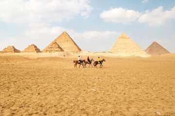 Panoramic view of Great Egyptian pyramids in Giza and three riders in front of them