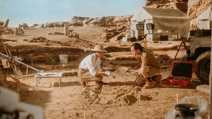 Archeological Digging Site: Two Great Archeologists Work on Excavation Site, Carefully Cleaning...