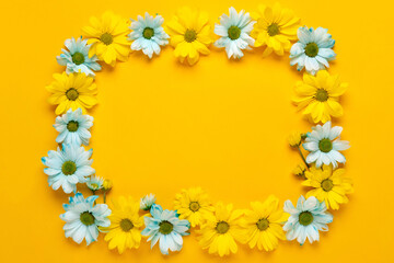 Spring flowers frame. Floral wreath on yellow background. Springtime. Flat lay, top view.