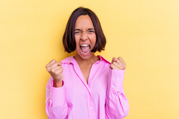Young mixed race woman isolated on yellow background cheering carefree and excited. Victory concept.