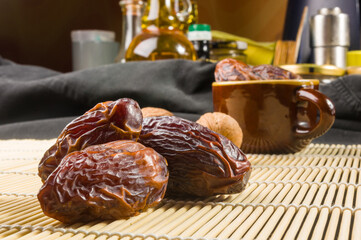 Big luxury dried date fruit on the bamboo mat, kurma ramadan kareem concept, close up.