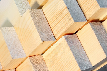 These are the ends of the planed wooden bars at the sawmill or in the carpenter's workshop. Industrial background