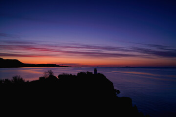 sunrise over a silhouette of Ha lighthouse in Aberdour, fife,  scotland.