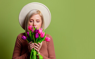 Beautiful woman in a hat with tulips bouquet