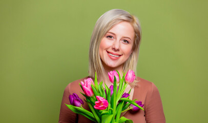 Beautiful blonde girl in brown blouse with tulips