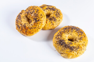 Freshly made and baked bagels on white background. Homemade cooking and pastry concept. Horizontal photo and selective focus