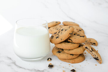 Homemade vegan cookies of cereal and glass of coconut milk on marble background. Recipe of sugar free cookies with raisins and nuts, vegan diet snack.