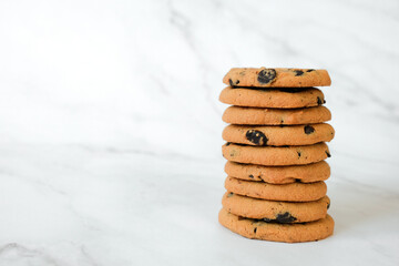 Stack of vegan cookies of oatmeal on marble background. Recipe of gluten free cookies with raisins, vegan diet snack. Copy space.