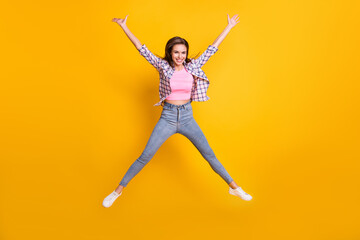 Fototapeta na wymiar Full length body size view of lovely skinny cheerful girl jumping having fun fooling isolated over bright yellow color background