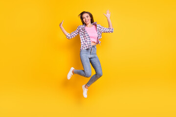 Fototapeta na wymiar Full length body size view of pretty slender cheerful girl jumping having fun isolated over bright yellow color background