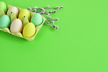Easter background with colorful eggs in cardboard box and pussy willow branches with catkins . Happy Easter Spring Festive greeting card. copy space