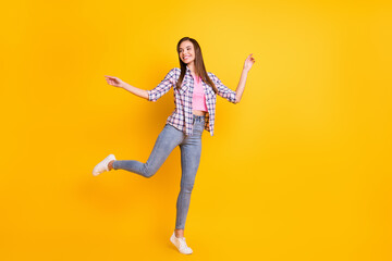 Fototapeta na wymiar Full length body size view of lovely slender cheerful girl jumping having fun isolated over bright yellow color background