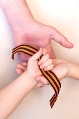 St. George ribbon in three children's hands, Defender of the Fatherland Day, Greeting card concept....