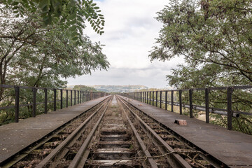 Obraz premium Railway track on a bridge, view of a cloudy sky, distancing perspective